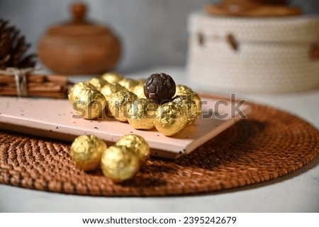 Round chocolate candies in a golden wrapper. Round candies. Golden color. A holiday gift. Birthday. Food photo. Sweet food. Happy birthday. Background image. Chocolate.