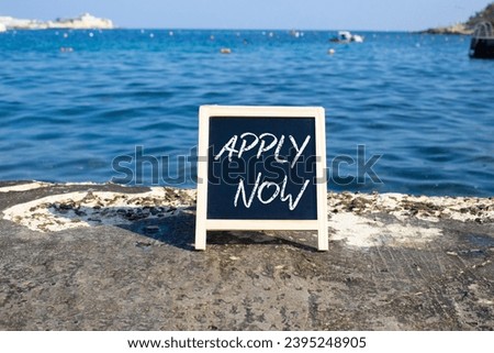 Apply now symbol. Concept word Apply now on black chalk blackboard. Beautiful sea background. Business and Apply now concept. Copy space