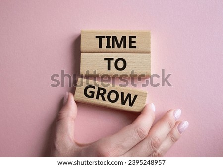 Time to Grow symbol. Concept word Time to Grow on wooden blocks. Businessman hand. Beautiful pink background. Business and Time to Grow concept. Copy space