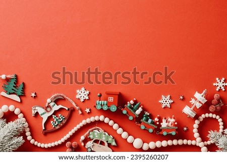 Vintage Christmas card. Wooden craft toys and decoration on red background. Flat lay, top view