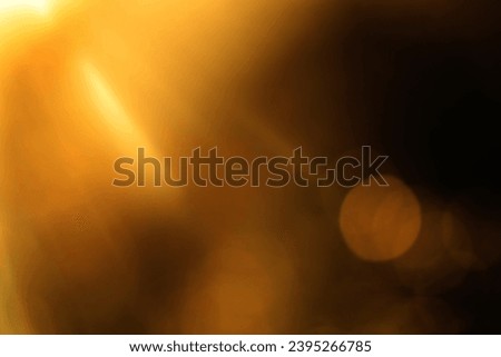 blurred image. shiny sun, sunbeams, sunrays, sunshine design. Yellow orange warm light effect, sun rays, golden beams isolated on black background. star dust Royalty-Free Stock Photo #2395266785