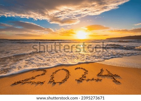 Happy New Year 2024 concept, lettering on the beach. Written text on the sea beach at sunrise