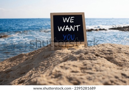 We want you symbol. Concept words We want you on black chalk blackboard blocks. Beautiful sea background. Business and We want you concept. Copy space.