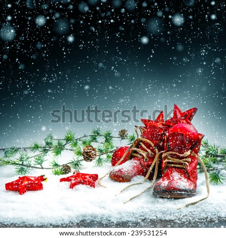 vintage christmas stocking with antique baby shoes. retro style colored picture with falling snow effect