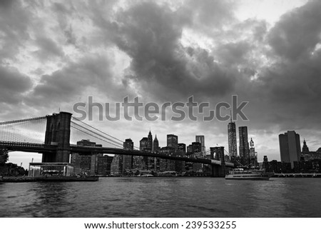 Brooklyn Bridge and New York skyline across the East River at twilight on a cloudy day. Toned.