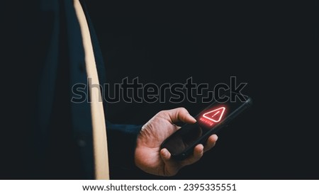 Man holding smartphone while using with red alert warning icon for virus infection. Ransomware malware attack, cybersecurity, hacking concept.