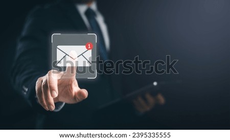 Businessman checking new incoming email message by pointing finger on virtual screen to touch on the email icon. Man in suit and necktie. Royalty-Free Stock Photo #2395335555