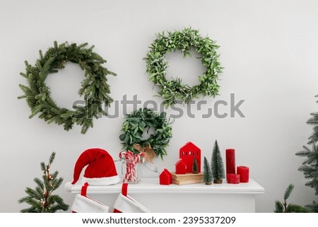 White mantelpiece with mistletoe wreathes and Christmas decorations
