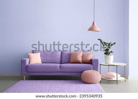 Interior of modern room with comfortable lilac sofa and table Royalty-Free Stock Photo #2395340935