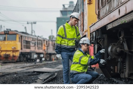 Locomotive engineering technicians maintain emission control on train railways, identifying oil and fuel leaks and inspecting, testing, and repairing malfunctioning engines for optimal efficiency. Royalty-Free Stock Photo #2395342523