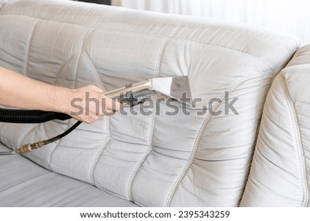 Commercial cleaning company concept. Depth sofa cleaning by a device. Before and after. Early spring regular cleanup. Royalty-Free Stock Photo #2395343259