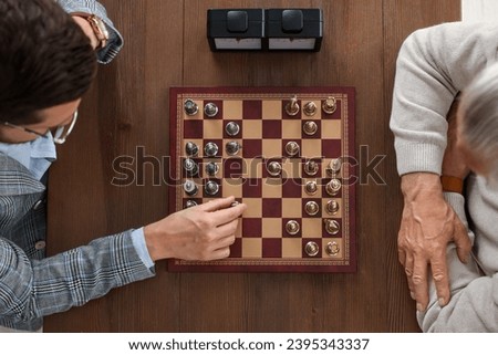 Men playing chess during tournament at wooden table, top view