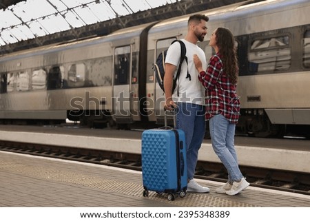 Long-distance relationship. Beautiful couple on platform of railway station, space for text Royalty-Free Stock Photo #2395348389