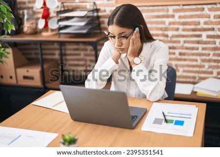 Young beautiful hispanic woman business worker tired using laptop working at office