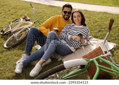 Beautiful young couple with takeaway coffee spending time together outdoors