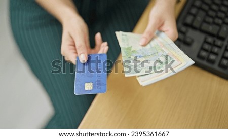 Young redhead woman business worker holding romanian leu banknotes and credit card at office Royalty-Free Stock Photo #2395361667