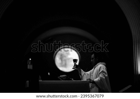 Silhouette of a priest during consecration of the Holy Eucharist in a Catholic Church Royalty-Free Stock Photo #2395367079