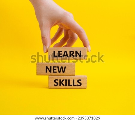 Learn new skills symbol. Concept words 'Learn new skills' on wooden blocks. Beautiful yellow background. Businessman hand. Business and Learn new skills concept. Copy space. Royalty-Free Stock Photo #2395371829