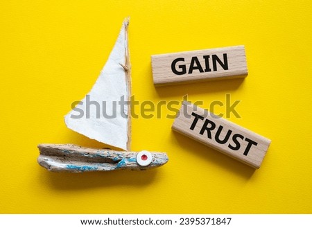 Gain trust symbol. Wooden blocks with words Gain trust. Beautiful yellow background with boat. Business and Gain trust concept. Copy space.
