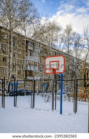 An empty snow-covered basketball court on a winter day