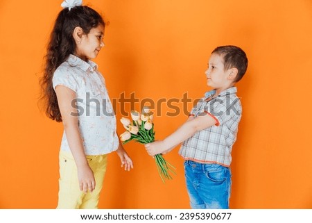 Little boy giving flowers to a girl