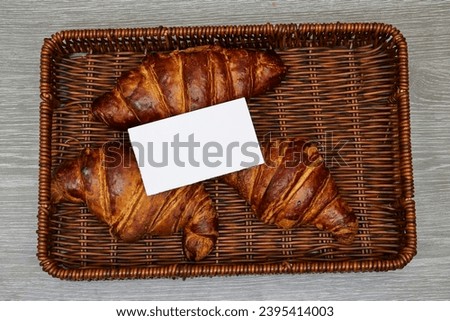 white card business above Fresh croissants in esparto halfah basket 