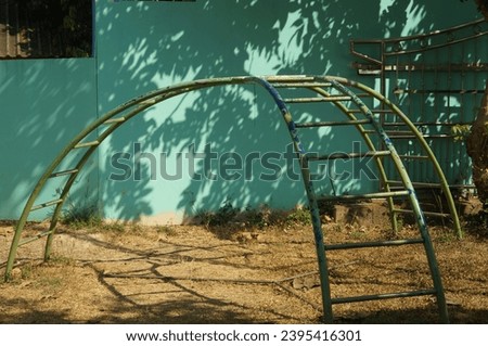 Green curved ladder on outdoor playground in Thailand.