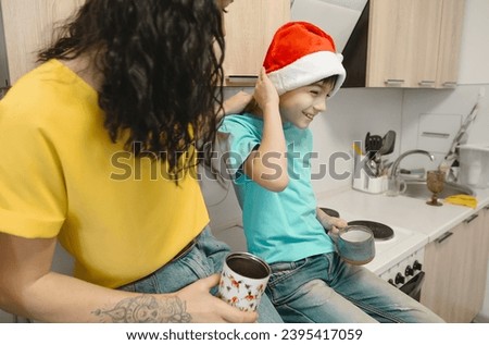 mother and son are sitting in the kitchen on the table in New Year's hats