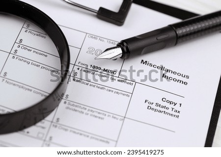 IRS Form 1099-misc Miscellaneous income blank on A4 tablet lies on office table with pen and magnifying glass close up Royalty-Free Stock Photo #2395419275