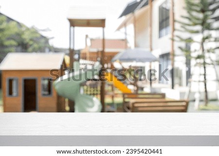 Empty wooden table with blur background of kids playground.