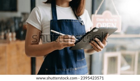 Startup successful small business owner sme woman stand with tablet  in cafe restaurant. woman barista cafe owner. 