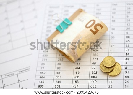 Heap of euro money bills in stationery clip on papers with calculations and receipts close up. Business and accounting concept