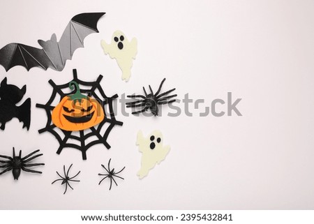 Flat lay composition with Halloween decor on white background, space for text