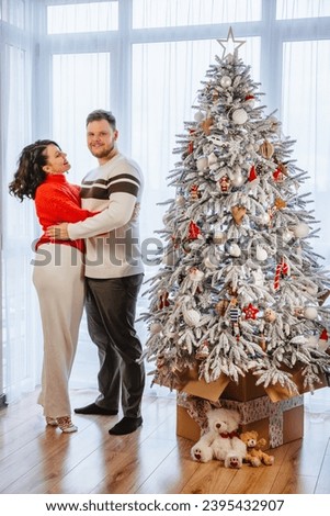 lovely couple dancing in front of christmas tree