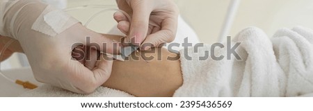 Close up of female lying in cosmetic chair while receiving IV infusion in medicine center Royalty-Free Stock Photo #2395436569