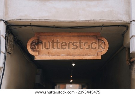 A light wooden sign against the backdrop of an arch and tunnel. Copy space. Lviv, Ukraine.