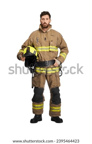 Serious bearded firefighter in uniform holding protective helmet in studio. Front view of middle aged male fireman with safety helmet, isolated on white studio background. Workplace, job concept. Royalty-Free Stock Photo #2395464423