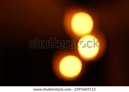 A bokeh shot of three pendant hanging spot light in darkness