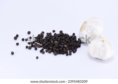 Garlic with skin and Black pepper on a white background. - close up photography.