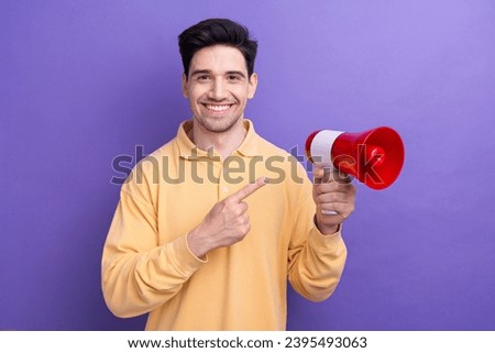 Photo of good mood funky guy wear yellow polo pointing finger loud speaker isolated violet color background