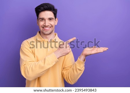 Photo of funky cool guy wear yellow polo showing arm pointing empty space isolated violet color background