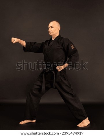 Portrait of aikido sensei master with black sensei belt in taekwondo kimono on black background. Traditional samurai hakama kimono. Healthy lifestyle and sports concept. Royalty-Free Stock Photo #2395494919