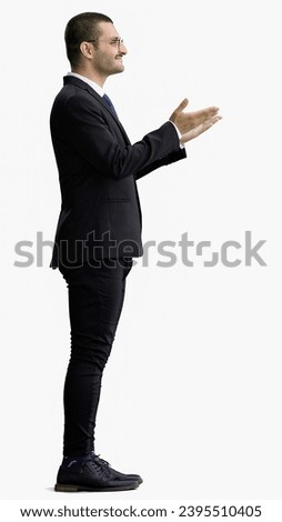 young man in full growth. isolated on white background demonstrates with hands