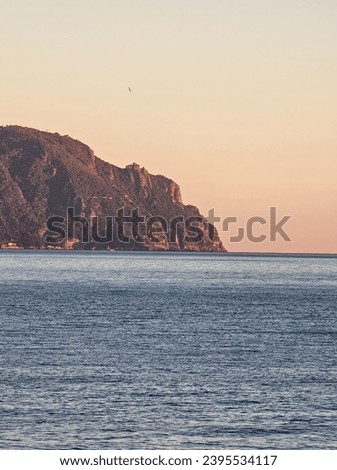 Genova Nervi, Italy - 23 November 2023: Beautiful sunset over the sea in winter days. Orange and red sky reflected over the water. Clear blue sky landscape.