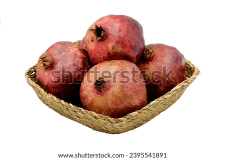 Pomes of pomegranates (Punica granatum) in a basket Royalty-Free Stock Photo #2395541891