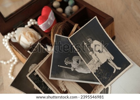 close-up dear to heart memorabilia in an old wooden box, lock of hair, stack of retro photos, vintage photographs 40s - 50s, concept family tree, genealogy, memories, home archive, keep as keepsake Royalty-Free Stock Photo #2395546981
