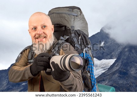 bearded man tourist photographer with a backpack photographs the beauty of nature in the mountains. nature hikes in the mountains