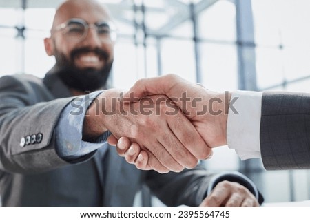 handshake in the office of two businessmen at the table Royalty-Free Stock Photo #2395564745