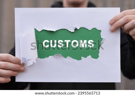 Man holding white and green sheets of paper with word: CUSTOMS. Concept of customs. Customs declaration clearance. Customs registration. Cargo delivery, import and export.