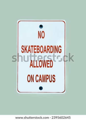 A red and white no skateboarding sign on campus sign